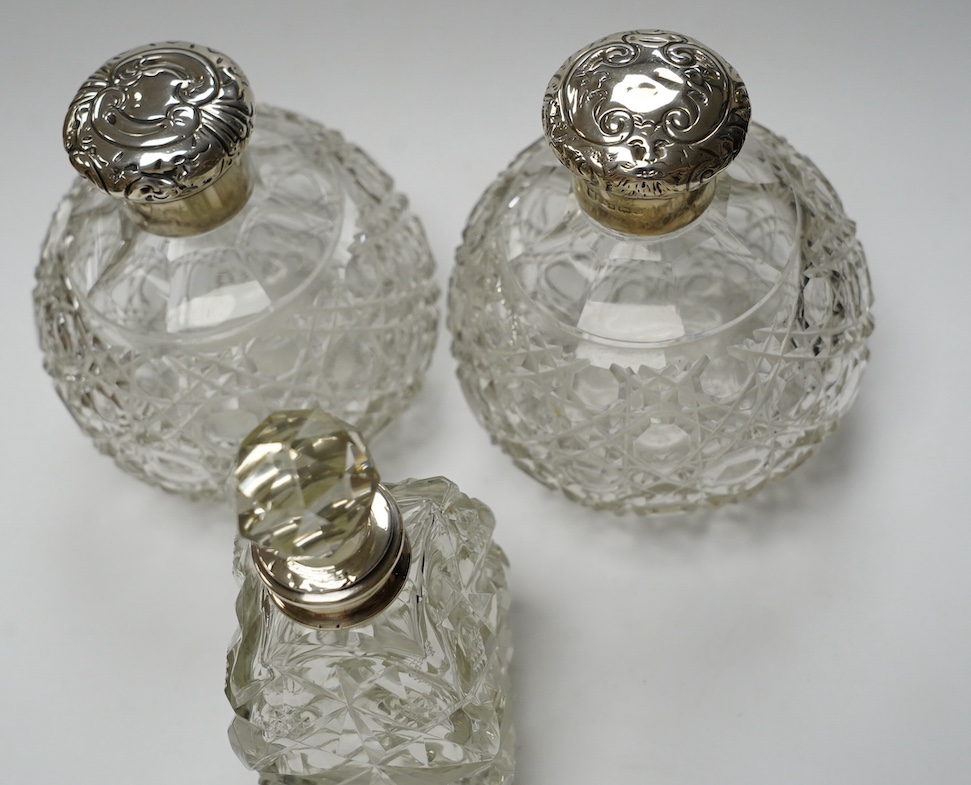 A pair of silver mounted cut glass scent bottles, marks rubbed, 12.3cm and one other silver mounted scent bottle. Condition - poor